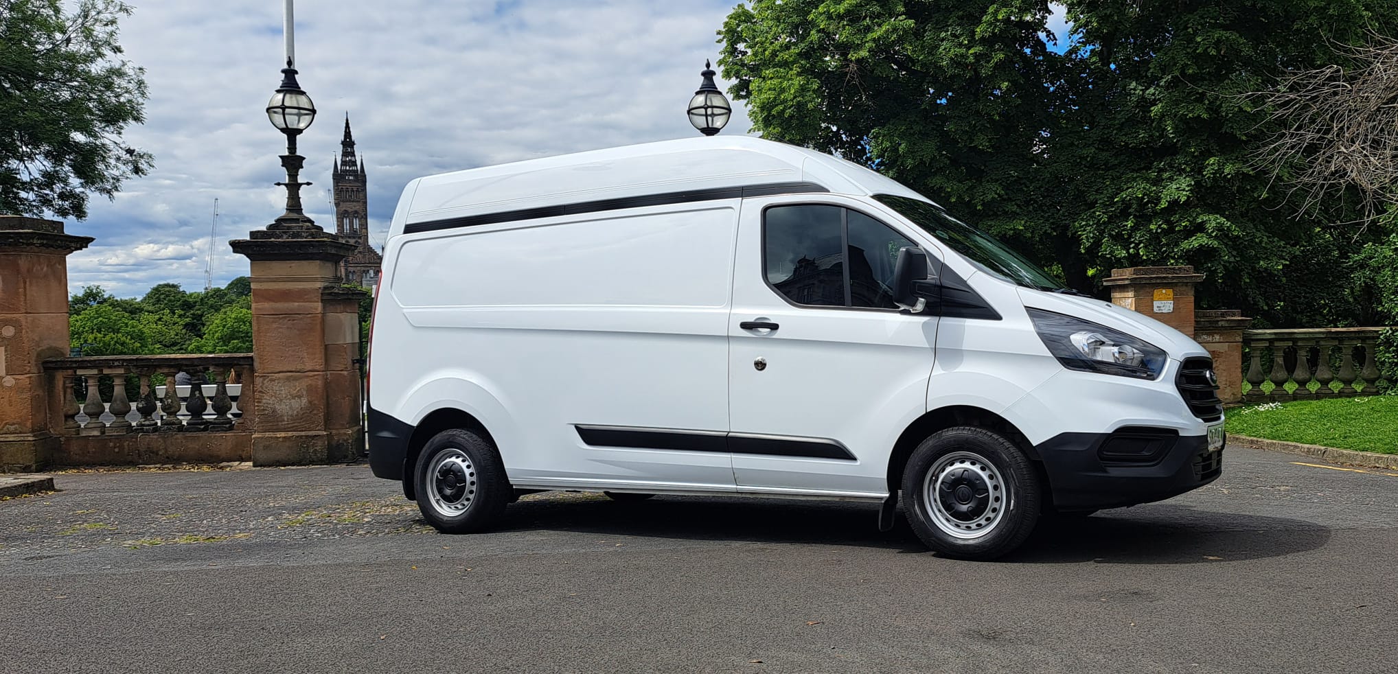 White Ford Transit high-top van parked outside Kelvingrove Park gates in Glasgow West End